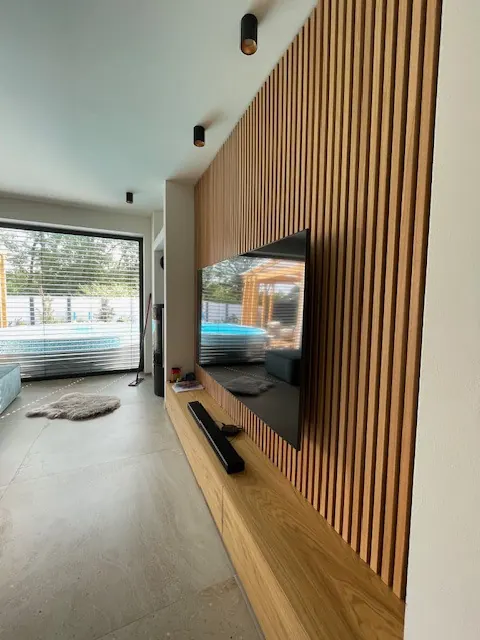 Interiér s drevenou obkladovou stenou a televízorom
